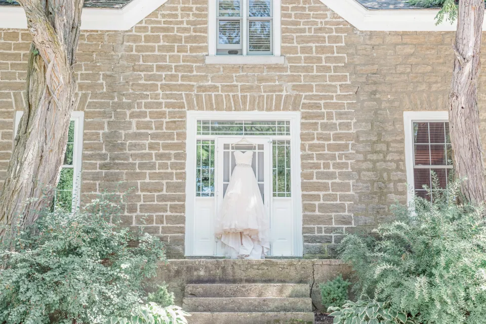 Hanging Wedding Dress - Getting Ready Space - Stonefields Estate-  Bright and Airy -  Natural Wedding Posing - Ideas for what to wear for Blush Wedding Photography, Modern Wedding Blush &. Navy Wardrobe inspiration- Unsure of what to wear for your wedding, we've got you! Romantic white with greenery, blush and navy theme. Grey Loft Studio is Stonefields Wedding and Engagement Photographer for Real couples, showcasing photos that are modern, bright, and fun.