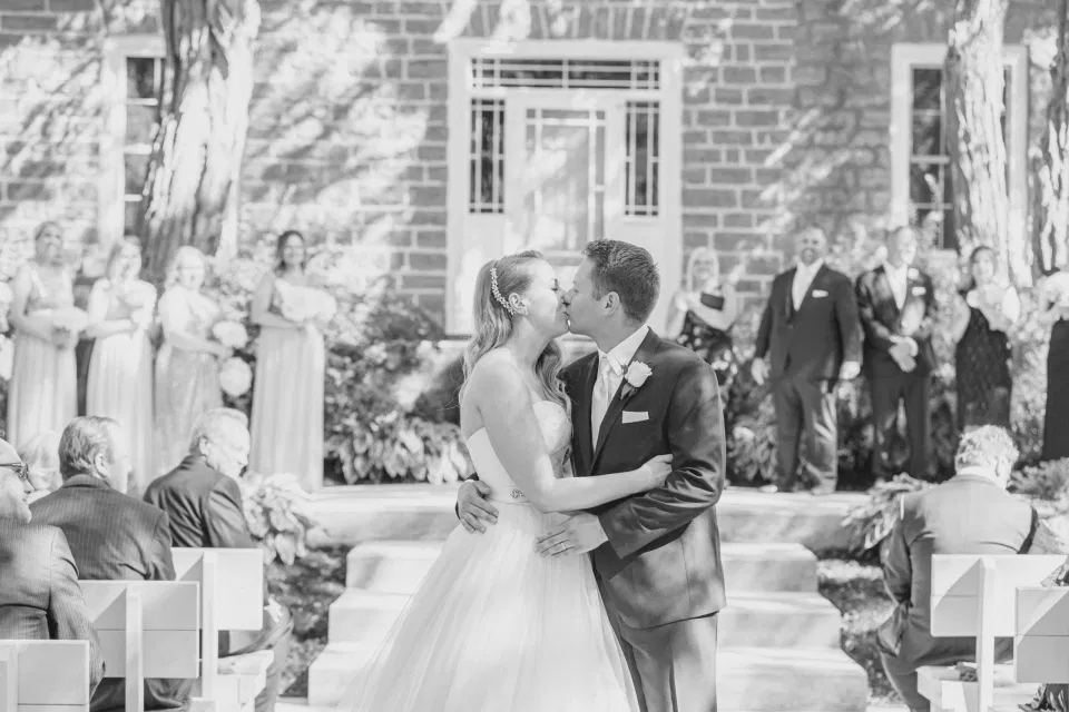 Mid Aisle Kiss -  Stonefields Estate-  Bright and Airy - Natural Wedding Posing - Modern Wedding Blush &. Navy Wardrobe inspiration-  Romantic white with greenery, blush and navy theme. Grey Loft Studio is Stonefields Wedding and Engagement Photographer for Real couples, showcasing photos that are modern, bright, and fun.