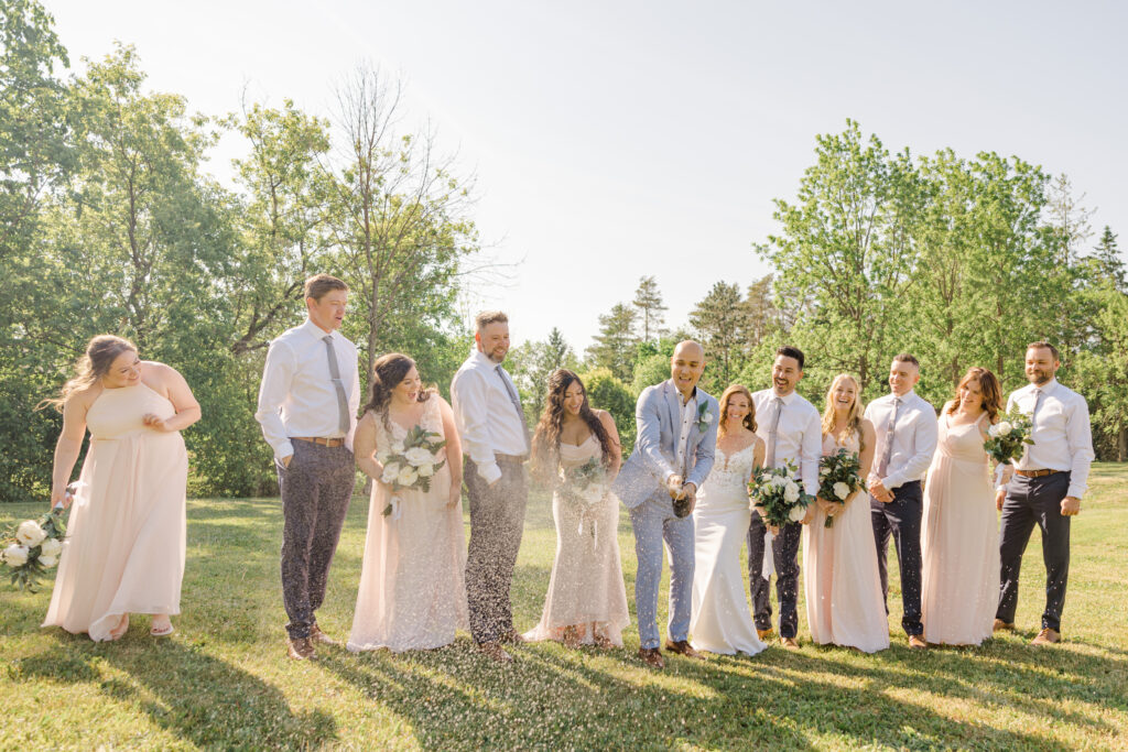 popping champagne as a wedding party with bride and groom