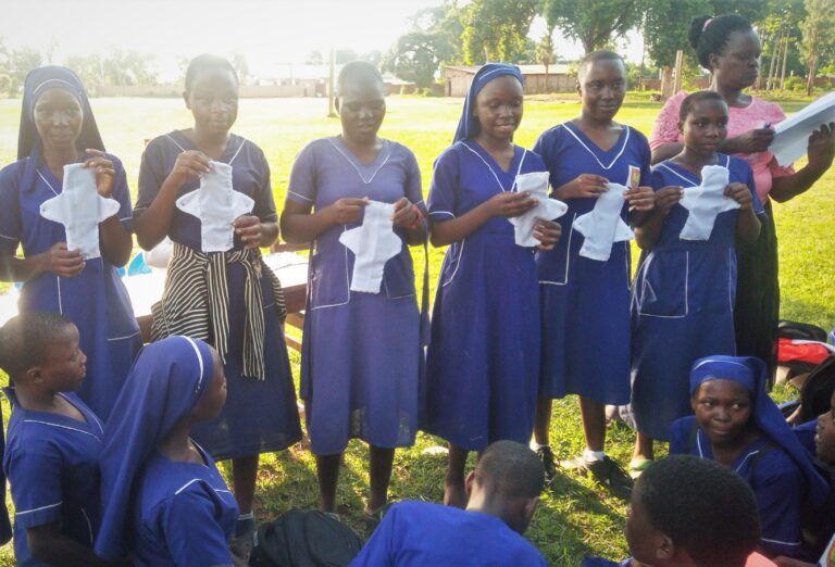Adolescent girls in Pallisa District proudly display reusable sanitary pads they made during GRiD's My Body, My Future menstrual health education program.