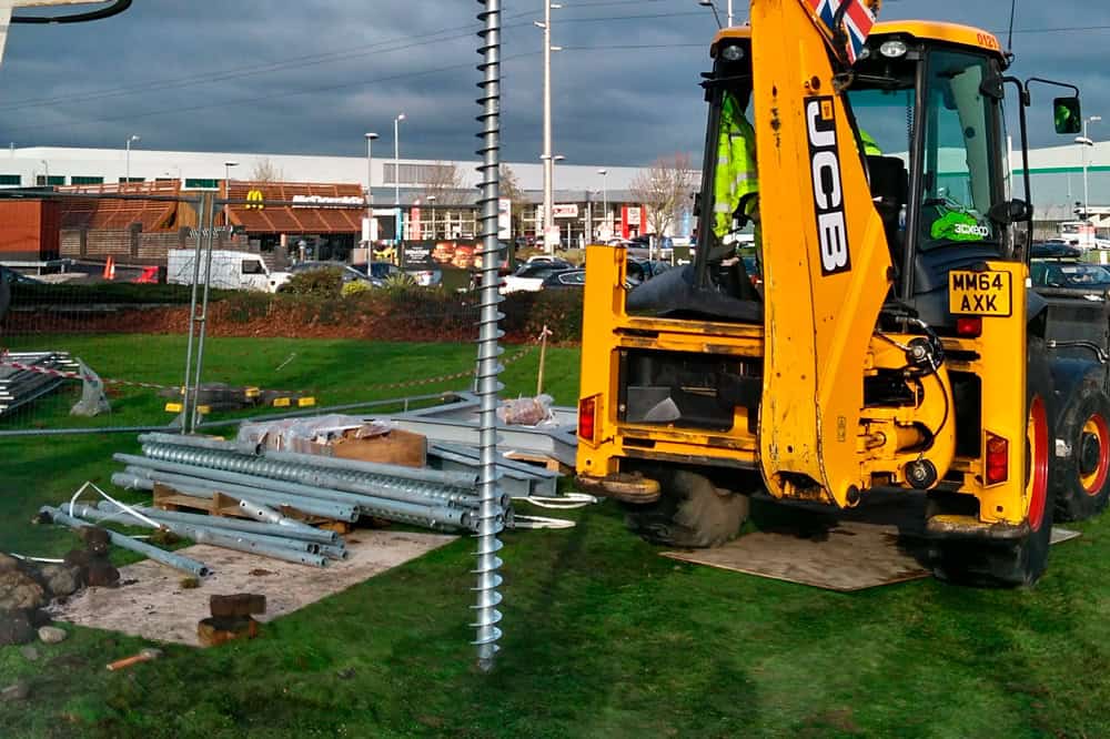 Installation of a large GroundPlug® TwisterTM Screw Pile. GroundPlug screw pile foundation being installed by a JCB 3CX machine.