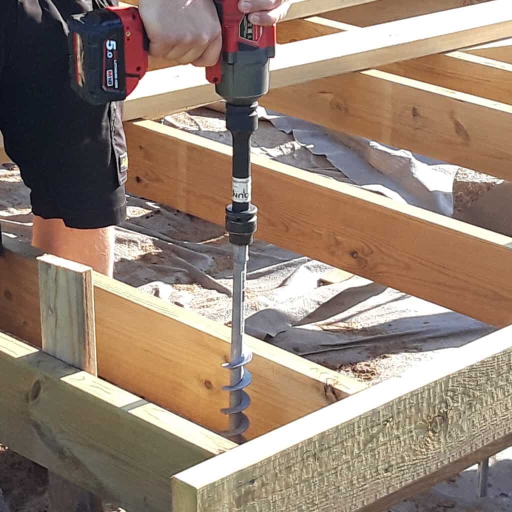 A GroundPlug® Twister Screw Pile Foundation is being screwed into the ground with an impact wrench.