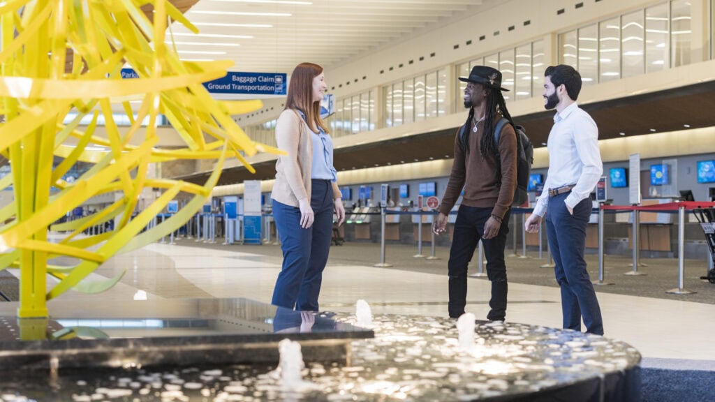 Airport visitors talking in the ticket lobby