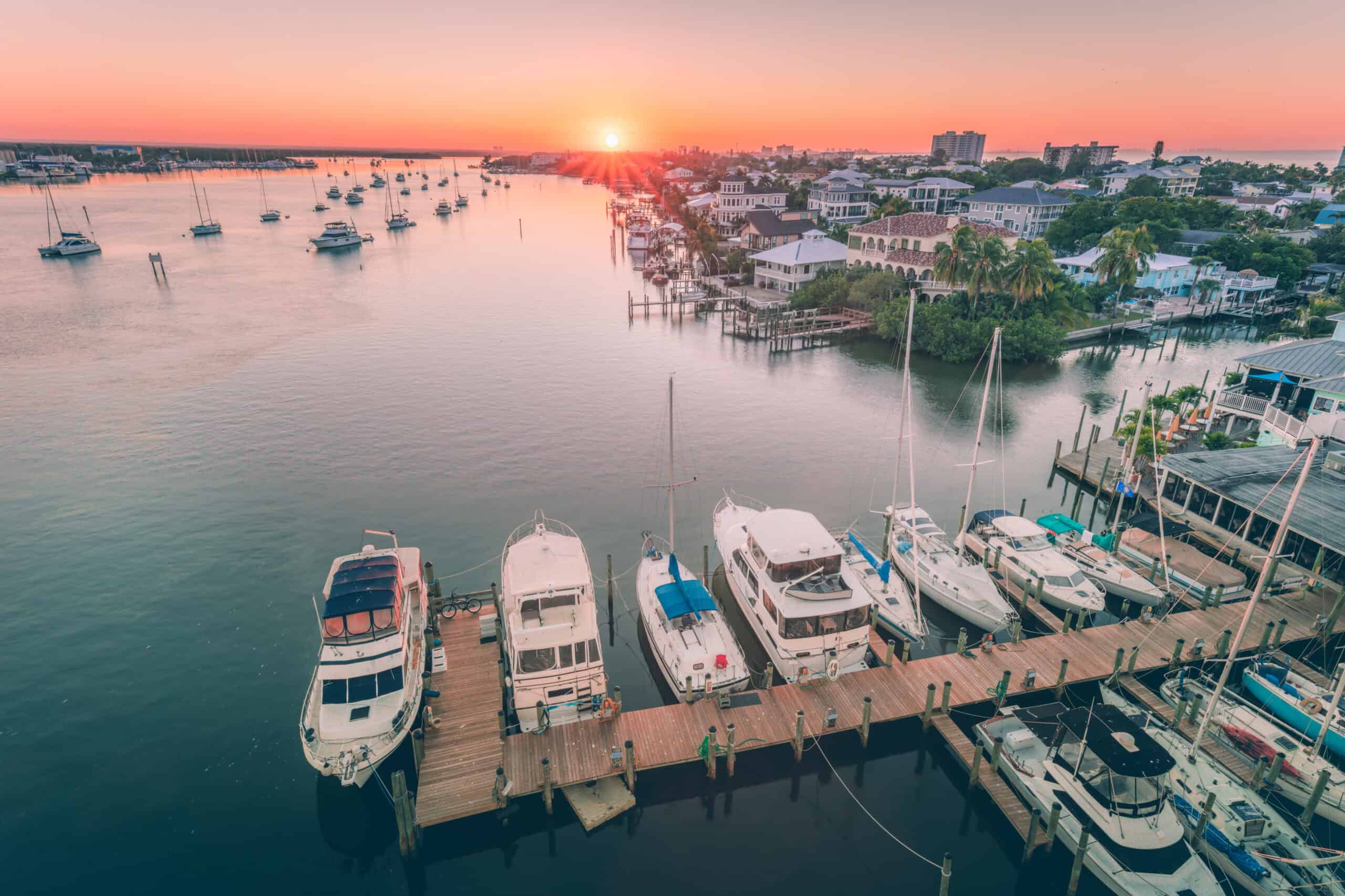 Sunset at Fort Myers marina with several boats in the water and docked.