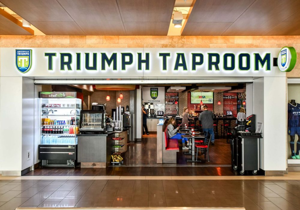 Triumph Taproom entrance with several people sitting at tables and dining in the restaurant.