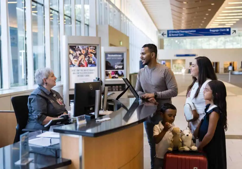 Image of an information desk representative helping out a family traveling through the GSP Airport.