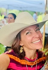 Shannon Mujica wearing a cowboy hat and a big smile.