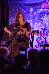 Marti Dodson sings and strums her guitar.