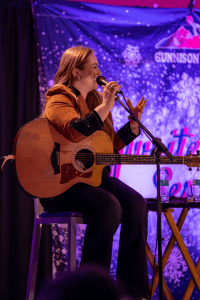 SJ McDonald laughing while telling a story on stage.