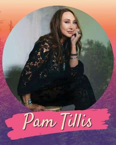 Pam Tillis wearing a black lacy top leaning her chin on her hand.