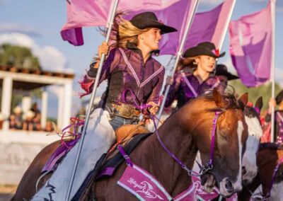 The Latigos Up Drill Team flies pink flags in formation.