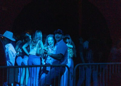 The crowd is having a great time dancing at Bull Fest under blue lights.