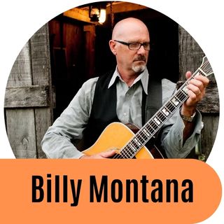 Billy Montana in a black shirt and black rimmed glasses looking down.