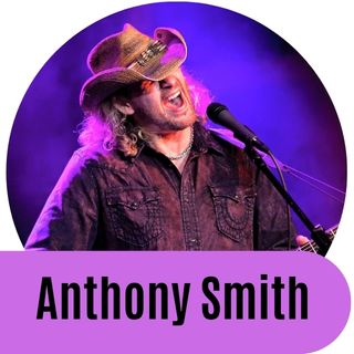 Anthony Smith wearing a cowboy hat, wearing a black shirt, and his guitar strap with the name, "Anthony". 