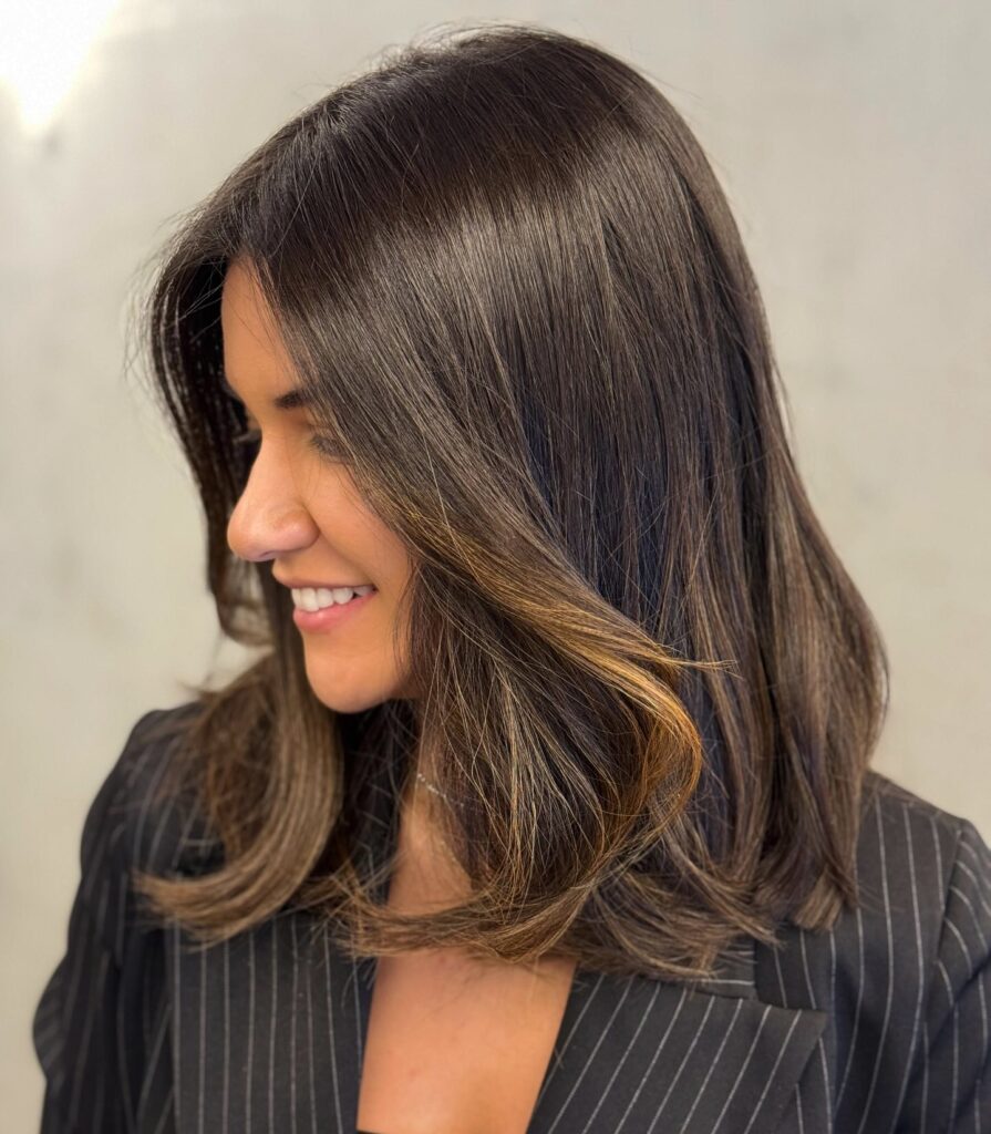 Flowy long bob with face-framing layers and golden highlights