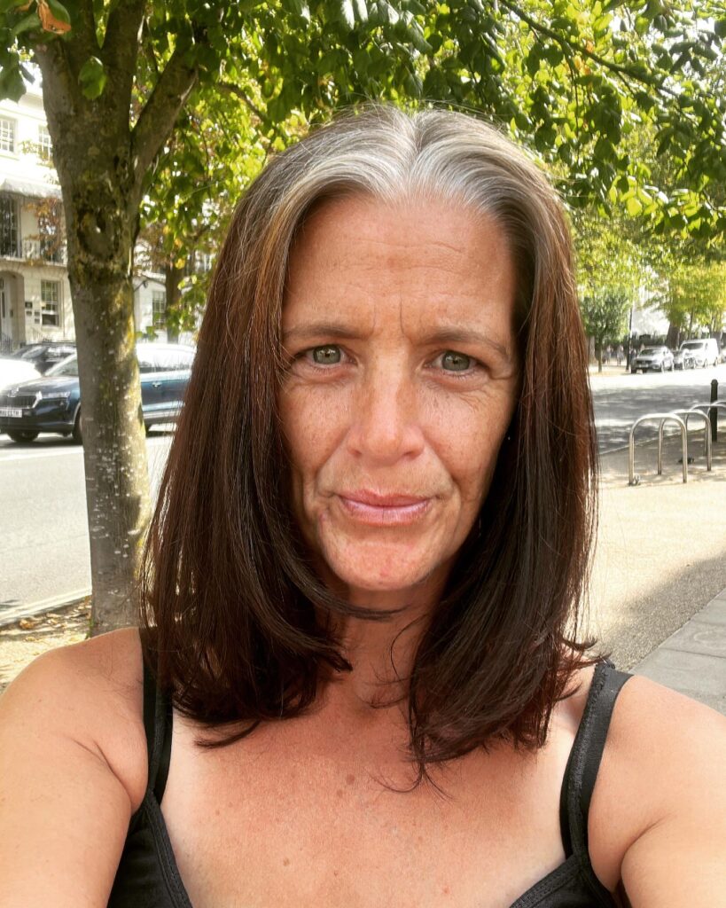Natural long bob with soft layers and a silver streak at the part