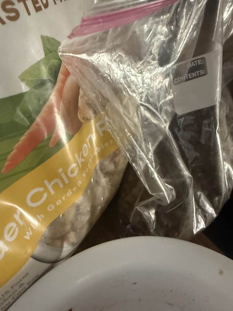 fresh dog food next to kibble with bowl in front