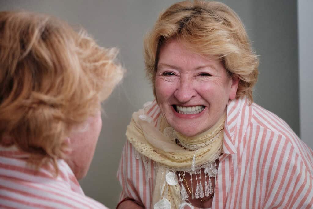 Elderly woman smiling happily during dental consultation at Haylo Dental.