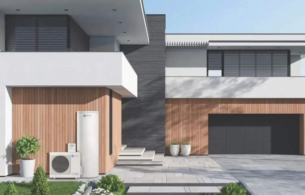 Modern house exterior with wood and dark gray accents, featuring a heat pump system unit installed near the entrance, and a paved driveway leading to a closed garage door.