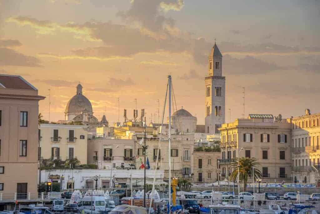 Seafront view of Bari Cityscape at sunset with Basilica of San Nicola and Romanesque Cathedral. .