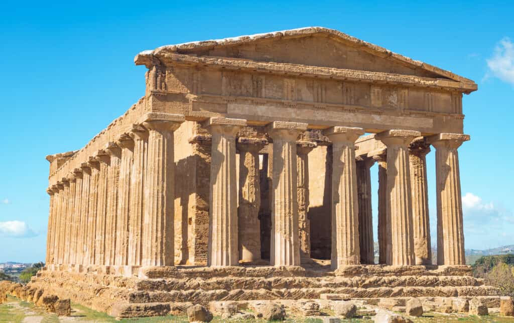 Historical Greek temple ruins with columns under a blue sky in this sicily travel guide