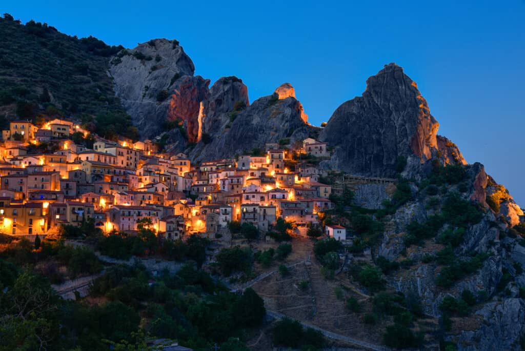 view of small village of Castelmezzano in the Lucanian Dolomites in Basilicata at dusk with warm lights from the houses.