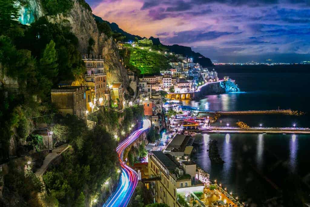 Early evening view of Amalfi, on the Amalfi coast, with the lights of the town reflecting on the sea