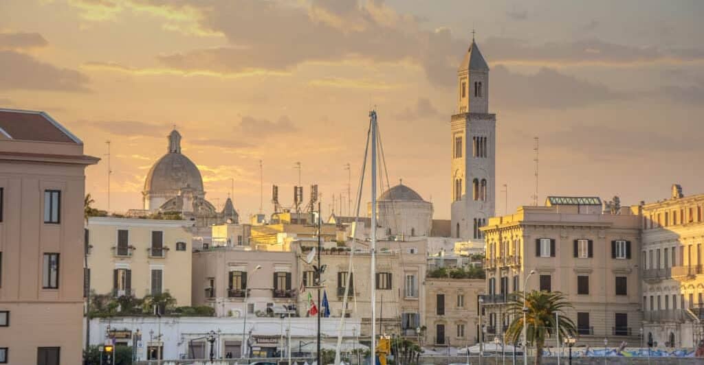 Seafront view of Bari Cityscape at sunset with Basilica of San Nicola and Romanesque Cathedral. .