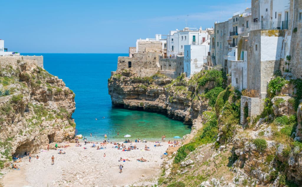 people on Cala Porto Beach, one of the Polignano a Mare beaches on a sunny day.