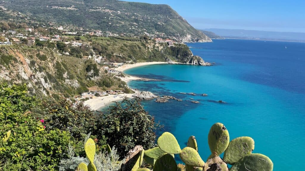 Beautiful view of Tropea's coast with cliffs, beach, and turquoise sea.