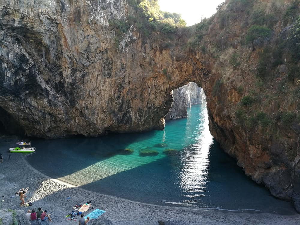 Arco Magno Beach in Calabria, Italy – Stunning hidden cove with a natural rock arch, crystal-clear turquoise water, and a secluded sandy shore, perfect for travel and nature lovers