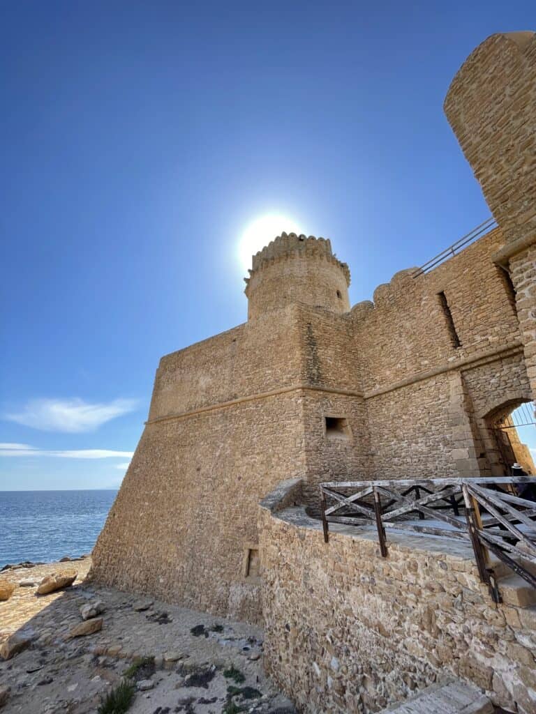 close view of the stone castle and its tower and entrance on a sunny day