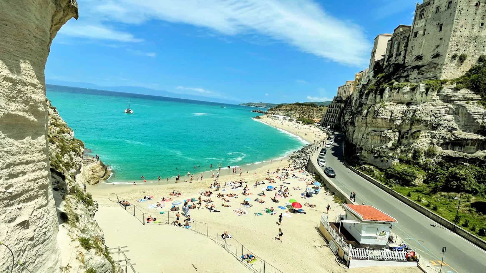 Scenic view of Tropea beach with turquoise waters and cliffs in Italy.