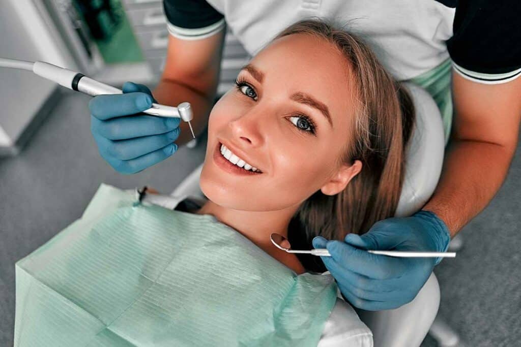 Bright woman smiling during dental checkup at Heritage Dental Edmonton clinic.