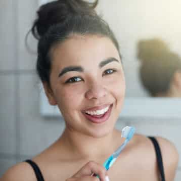 Family Dentist in South Edmonton | Heritage Dental 9 Girl smiling with white teeth and a toothbrush