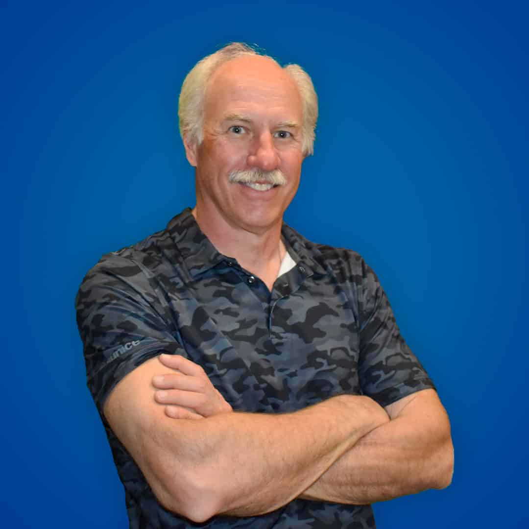 Friendly male dentist with white hair and mustache at Heritage Dental Edmonton.