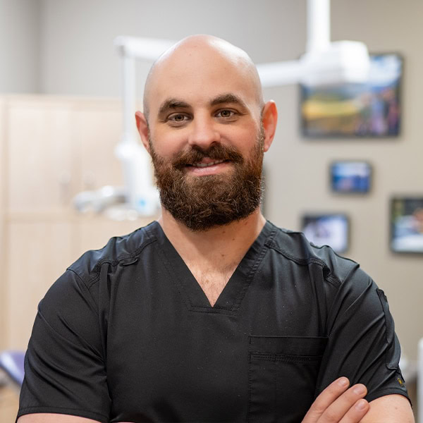 Friendly male dentist at Heritage Dental Centre Edmonton, smiling in dental office setting.