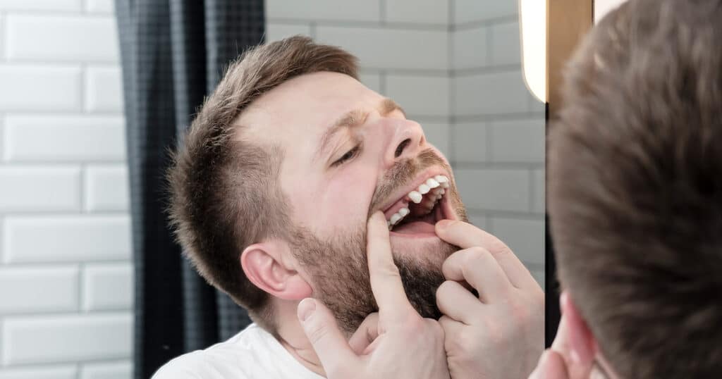 Chiropractic examination of man's teeth in dental clinic, patient seeking dental health care.