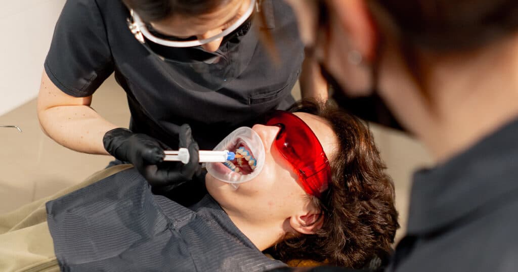 Teeth Whitening Options in Edmonton 5 Woman in dental chair getting her teeth whitened by a dentist