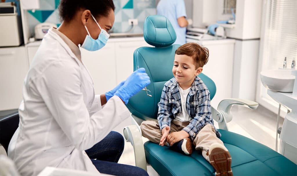 Caring for Your Children's Teeth: A Parent’s Guide 1 Little boy talking to african american dentist
