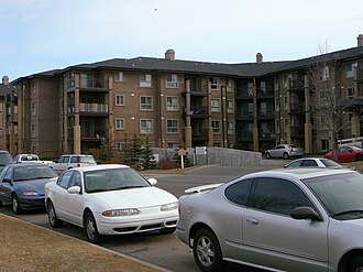 Modern multi-story dental clinic building in Edmonton with parking lot in front.