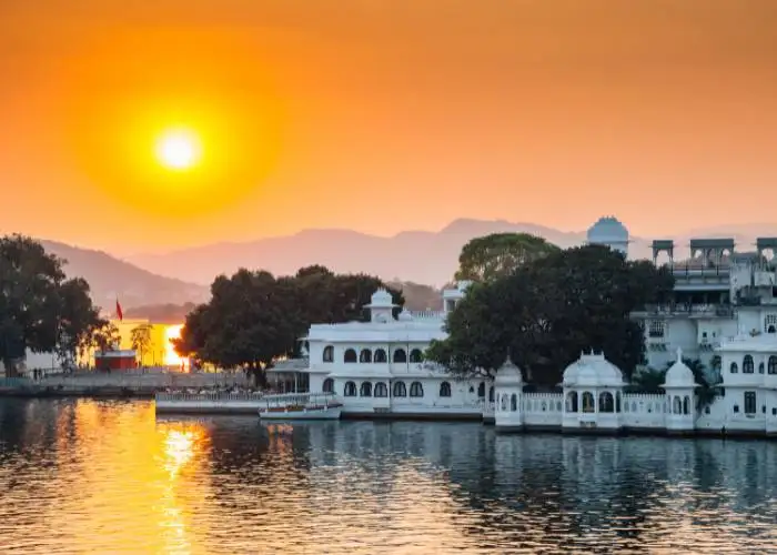 Sunset over Lake Palace in Udaipur, Rajasthan, showcasing traditional architecture and serene waters.