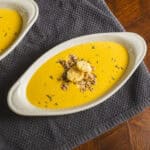 Creamy butternut squash soup topped with shredded chicken, croutons, and herbs in a white oval bowl. Perfect for warm, comforting meals and easy to prepare with fresh ingredients.
