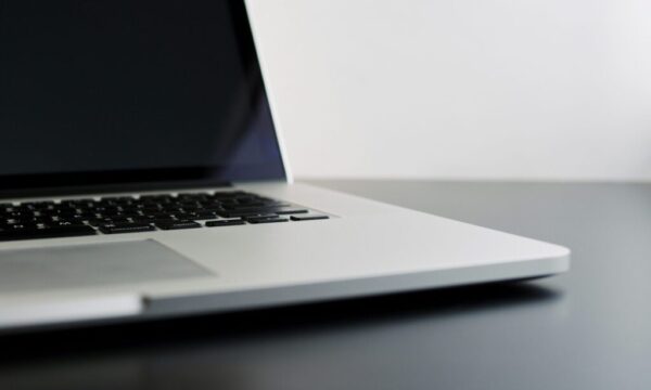silver laptop computer on black table