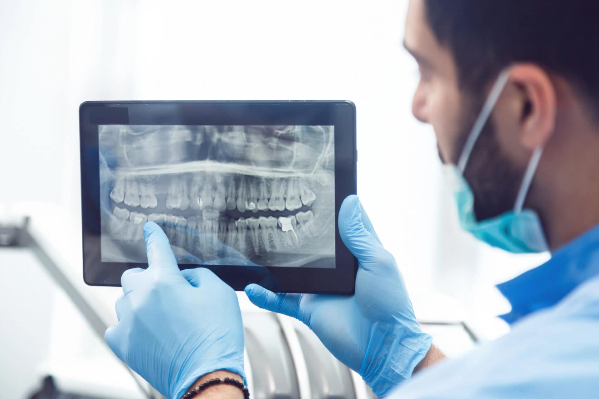 Dentist showing teeth x-ray on tablet
