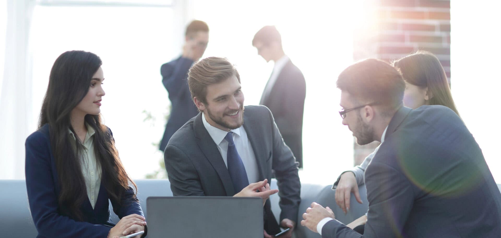 Beautiful business people are using gadgets, talking and smiling