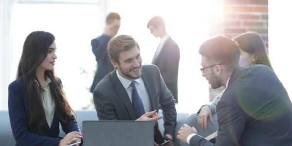 Beautiful business people are using gadgets, talking and smiling