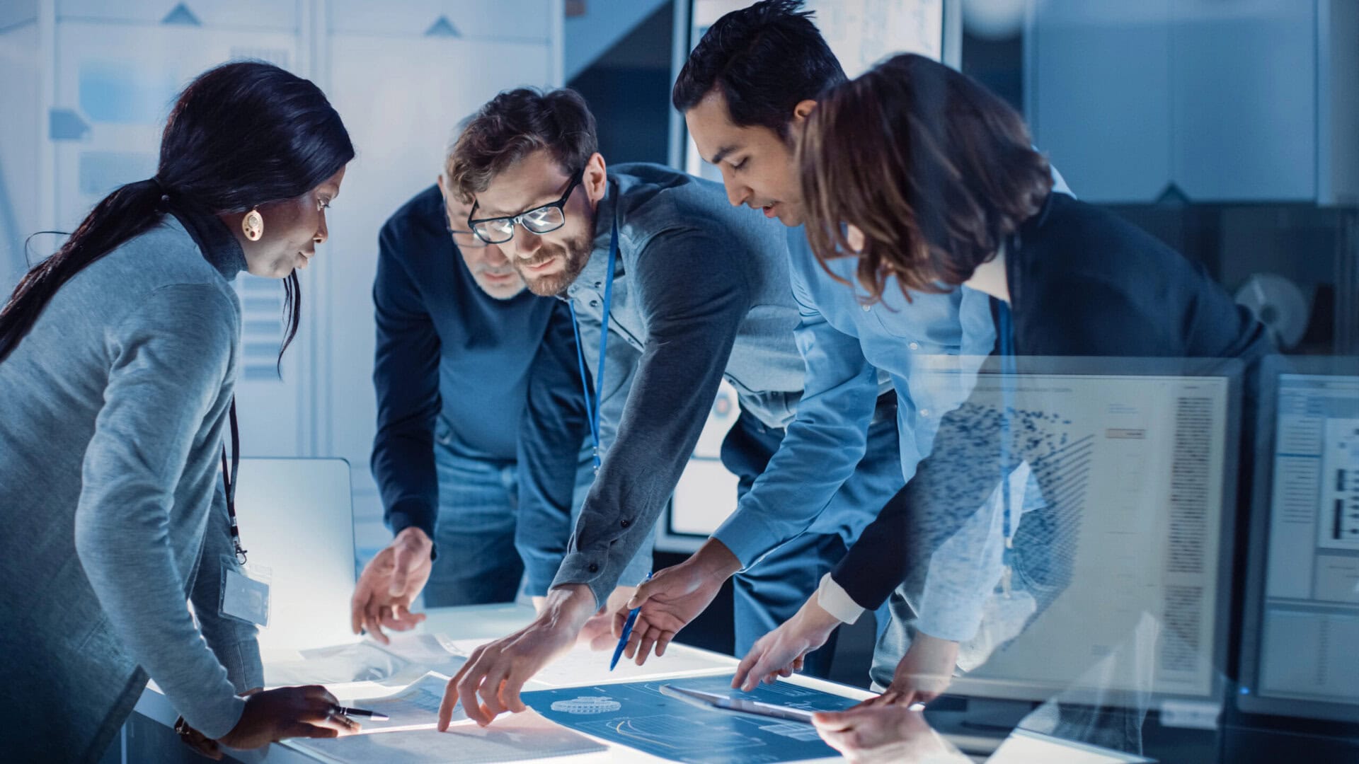 Engineers Meeting in Technology Research Laboratory: Engineers, Scientists and Developers Gathered Around Illuminated Conference Table, Talking and Finding Solution, Inspecting and Analyzing