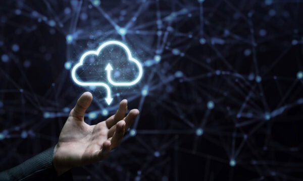 The hand shows a computing cloud on a blurred dark background.