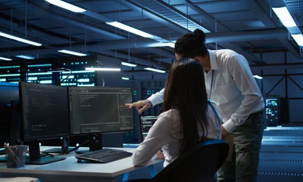 Computer scientists in data center managing and maintaining databases, ensuring data integrity and security.